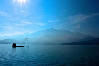 Scenic view of sun moon lake and mountains against blue sky