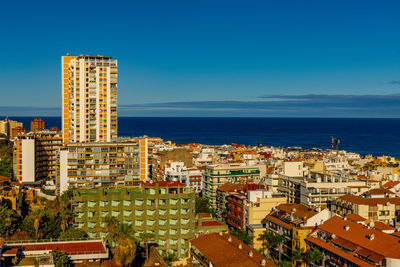 Buildings by sea against sky