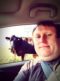 Portrait of woman with dog in car