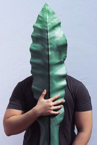 Man standing behind leaf