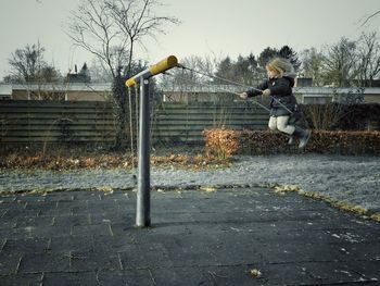 Boy playing with trees in background