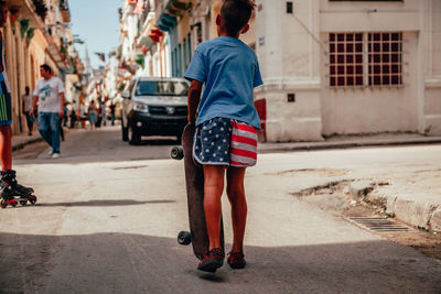 Rear view of man walking on street in city