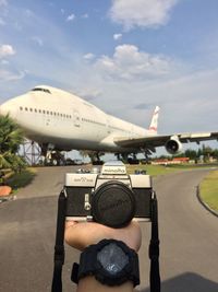 Airplane on airport runway against sky