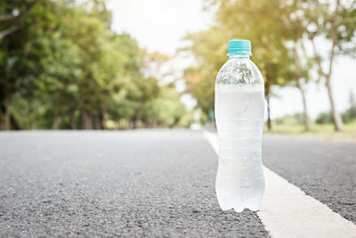 Close-up of white bottle on road