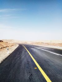 Road passing through land against sky