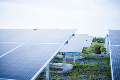 Solar panels on field against sky