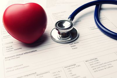 Close-up of heart and stethoscope on papers