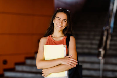 Portrait of a smiling girl with a folder in her hands