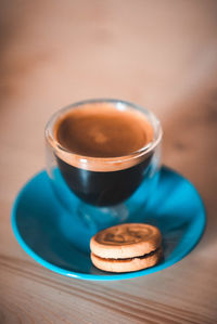 Close-up of coffee in cup with cookie on table