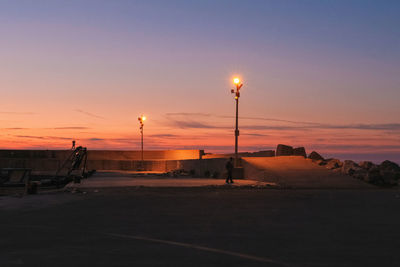 Street lights against sky during sunset