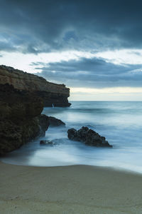 Boulder on sandy beach at sea