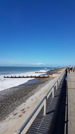 Scenic view of beach against clear blue sky