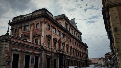 Low angle view of buildings against cloudy sky