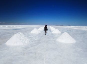 Man on snow covered landscape against sky