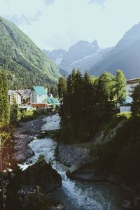 River amidst buildings and mountains against sky