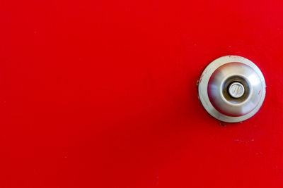 Close-up of electric lamp against red wall