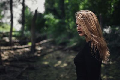 Young woman standing in forest