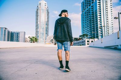 Full length of man standing in city against sky