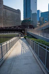 Footbridge over city buildings against sky