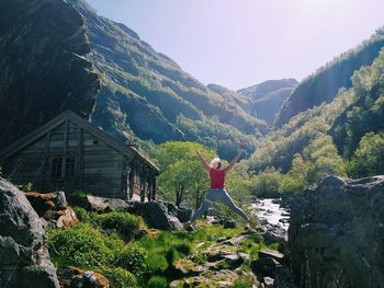 Rear view of man standing on mountain against sky