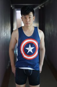 Portrait of young man standing in corridor of building