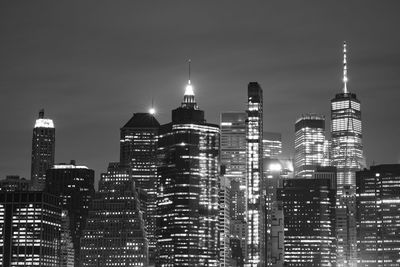 Illuminated buildings in city against sky at night