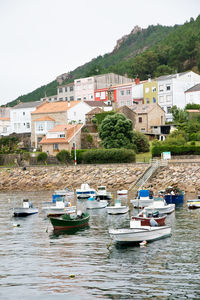 Sailboats moored on lake against buildings in city