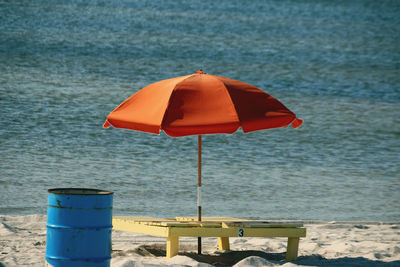 Deck chairs on beach against sea