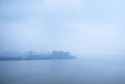 Scenic view of sea against sky in city