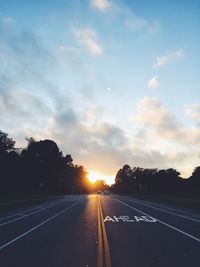 Road passing through sunset