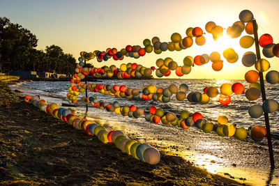 Multi colored umbrellas on land against sky during sunset