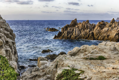 Rock formation on beach against sky