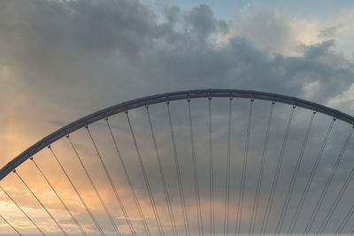 Low angle view of bridge against cloudy sky