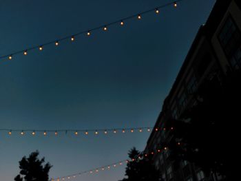 Low angle view of illuminated christmas lights against clear sky at night