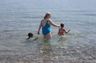 Rear view of family playing in sea