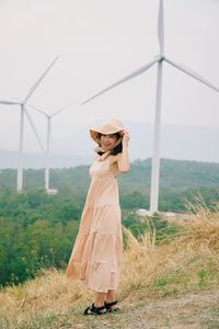 Woman wearing hat standing on field