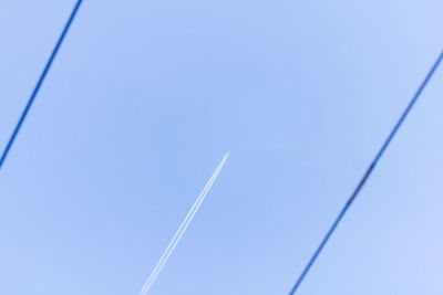 Low angle view of vapor trail against clear blue sky