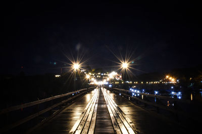 Illuminated bridge against sky at night