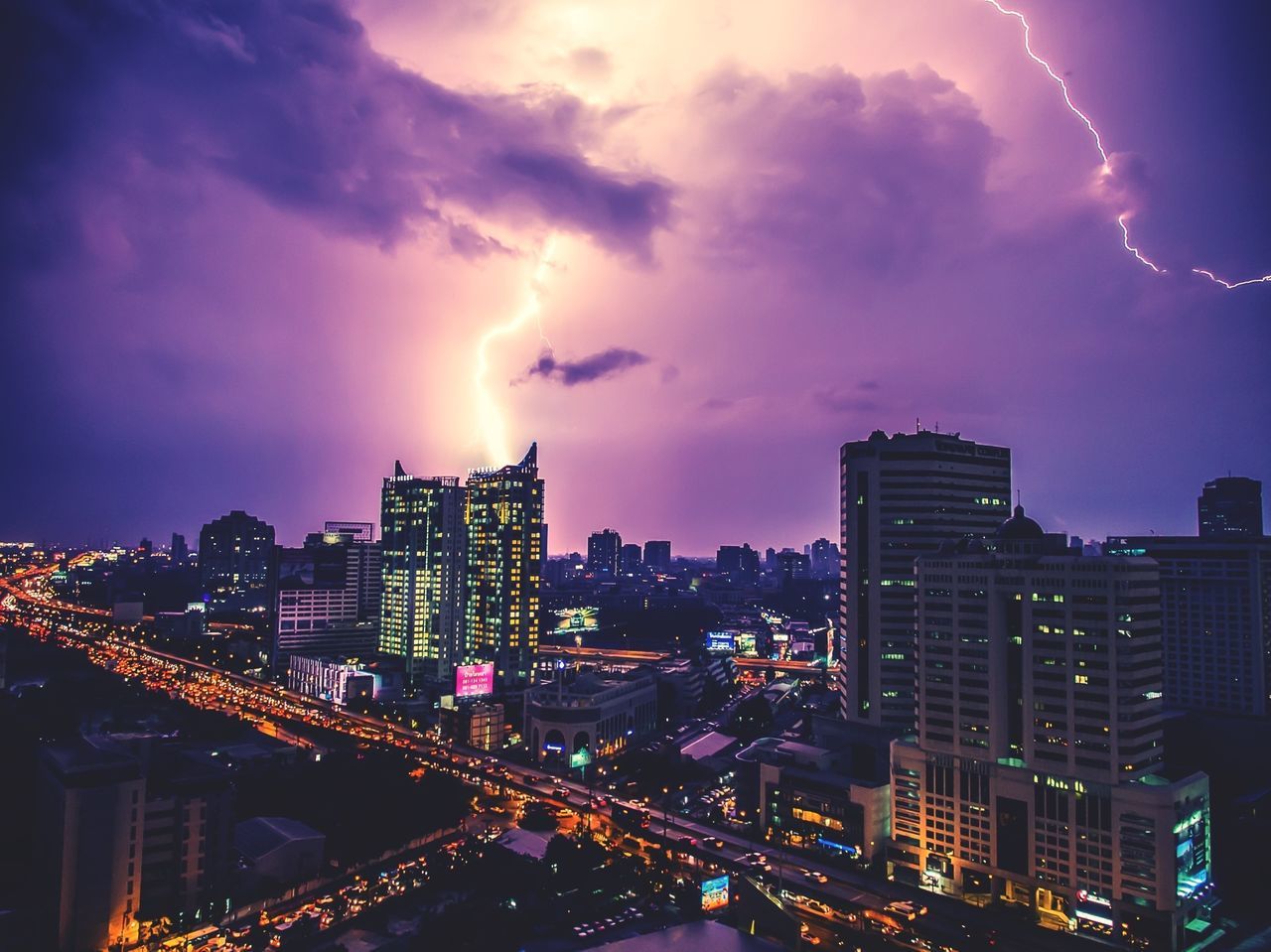 illuminated, night, city, building exterior, cityscape, architecture, sky, built structure, cloud - sky, city life, light - natural phenomenon, dusk, high angle view, residential district, residential building, glowing, outdoors, long exposure, dramatic sky, no people