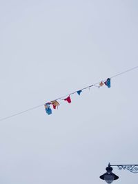 Low angle view of flags hanging against clear sky