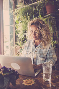 Young woman using laptop at table