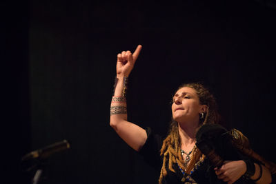 Low angle view of woman with arms raised