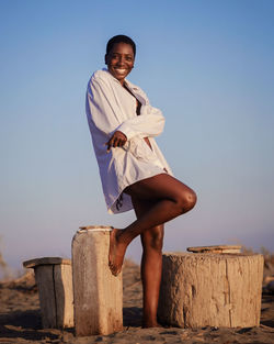 Portrait of teenage girl standing against clear sky