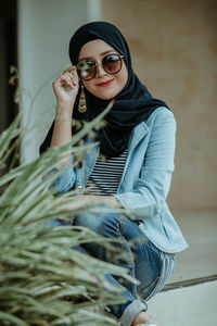 Portrait of smiling young woman wearing sunglasses