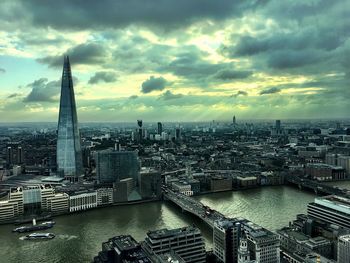 Aerial view of cityscape against cloudy sky