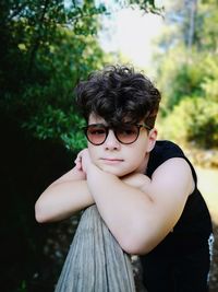 Portrait of girl in sunglasses against trees