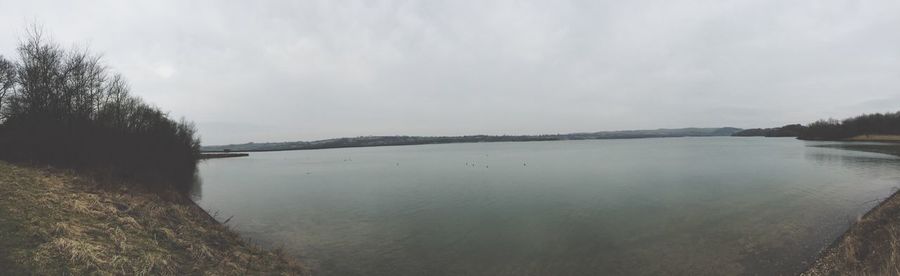 Scenic view of lake against cloudy sky