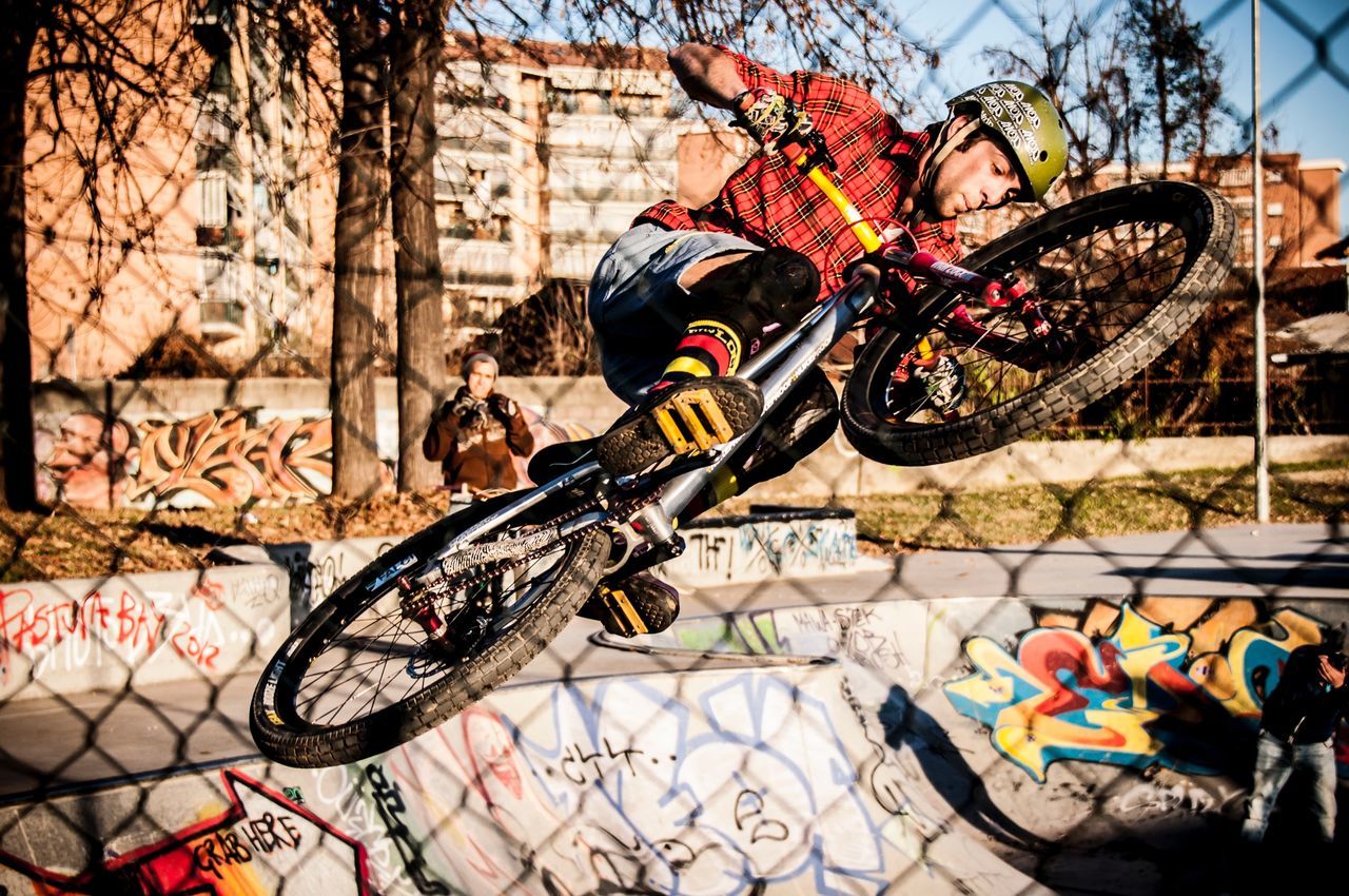 bicycle, land vehicle, transportation, mode of transport, building exterior, architecture, built structure, wall - building feature, stationary, street, parking, graffiti, day, parked, sunlight, leaning, outdoors, wall