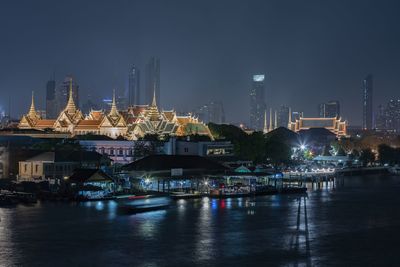 Bangkok thailand - the temple of the emerald buddha and the chao phraya river at night