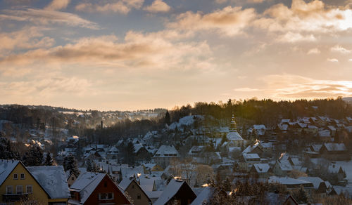 Houses in town against sky during winter